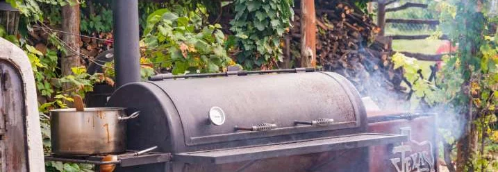 Ein großer Smoker steht im Garten.